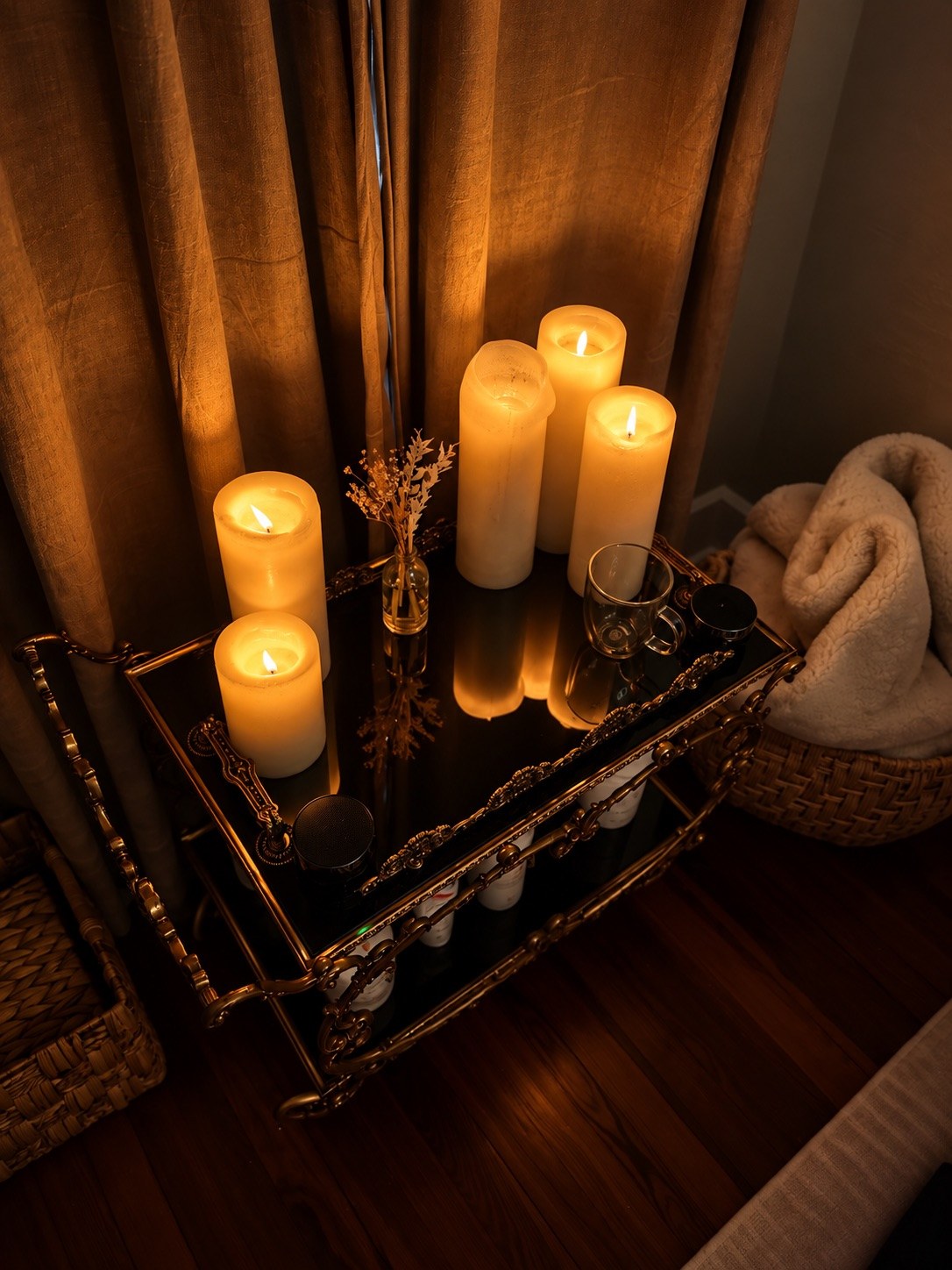 Brass tea cart with pillar candles, dried flowers and folded towels in the candlelit Root Room, The Bronze Lily, St. Petersburg, FL